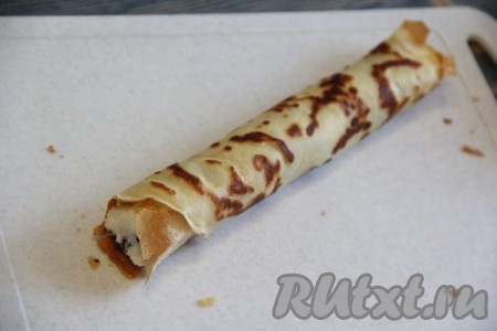  Свернуть блин с начинкой в плотную трубочку.