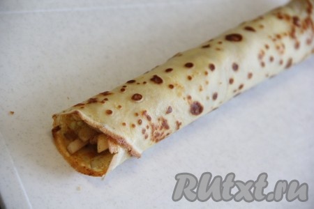  Свернуть блин с яблочной начинкой в плотную трубочку.