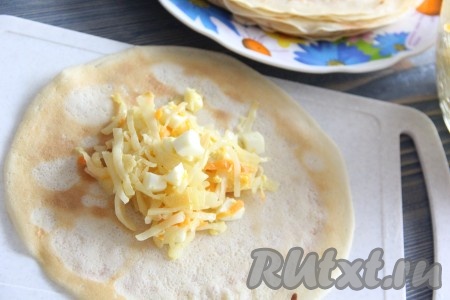 Выложить 1-1,5 столовых ложки начинки&nbsp;из капусты с яйцом на серединку блина.