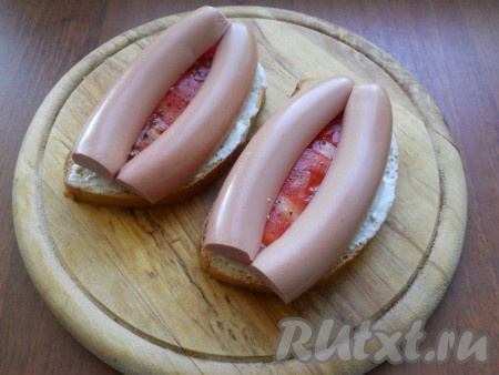 На помидоры выложить сосиски, разрезанные вдоль.
