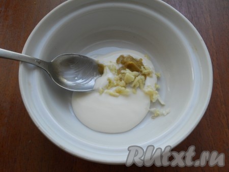 К сметане добавить измельченный чеснок и горчицу, перемешать.