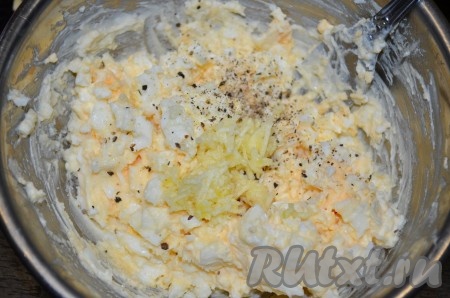 Добавить натёртый на мелкой тёрке (или пропущенный через пресс) чеснок, соль и чёрный молотый перец, перемешать яично-сырную массу.