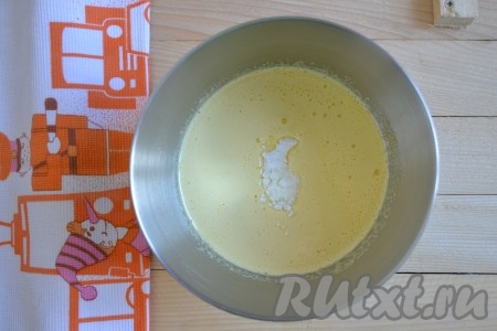 Яйца взбиваем в отдельной ёмкости до получения однородной массы. Взбитые яйца, соду, ванилин и сахар добавляем в молозиво, тщательно перемешиваем (сахар должен раствориться).
