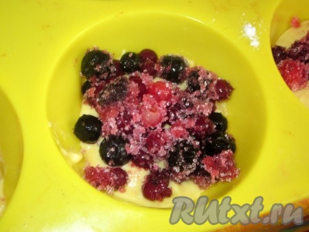 Ягоды смешать с сахаром (количество сахара зависит от сладости ягод) и равномерно распределить в формочки поверх теста.
