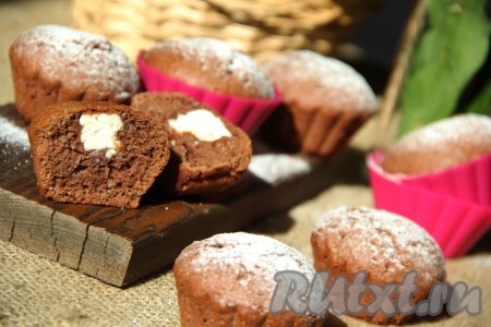 Готовые шоколадные кексы слегка остудить, достать из формочек. Перед подачей вкусные, аппетитные кексы с нежнейшей начинкой из творожного сыра можно посыпать сахарной пудрой. 