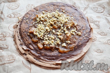 Для того чтобы орехи раскрыли свой богатый вкус и аромат, необходимо их заранее в течение 10 минут подсушить в духовке, разогретой до 180 градусов. 1-2 раза во время сушки орешки необходимо перемешать. Важно не пересушить, чтобы в орешках осталось немного влаги (пересушенные орехи могут горчить). Яблочный джем равномерно распределить по блину, оставляя края чистыми. Остывшие орехи немного растолочь и посыпать ими джем, которым смазывались шоколадные блины.
