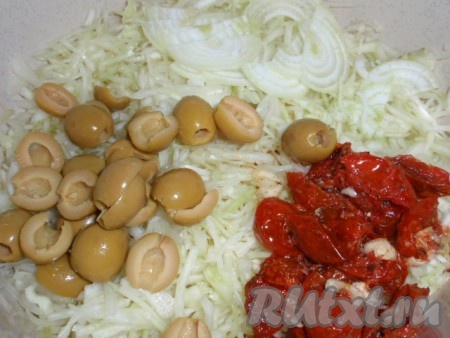 Добавляем к капусте нарезанный полукольцами лук, разрезанные на две части оливки и ломтики вяленых помидоров.