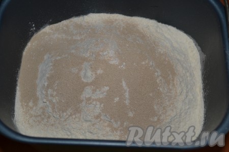 Муку дважды просеиваем. В чашу хлебопечки всыпаем просеянную муку и дрожжи. Кунжут и семена льна насыпаем в лоток для сыпучих добавок, хлебопечка подаст сигнал, когда их нужно добавить. Включаем хлебопечку.
