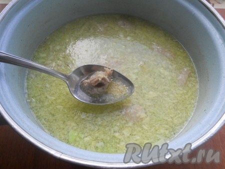 В бульон отправить пшено, измельченную капусту и кусочки мяса. Варить все на слабом огне 15 минут.