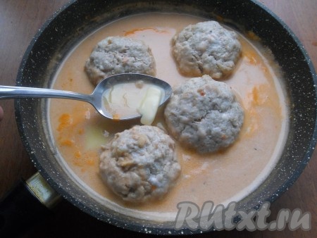 Поставить сковороду на огонь, прикрыть крышкой, довести до кипения, затем огонь уменьшить и тушить тефтели с цветной капустой 20 минут на слабом огне. Затем тефтели перевернуть, добавить в соус сливочное масло, также прикрыть сковороду крышкой. Тушить ещё 15 минут.