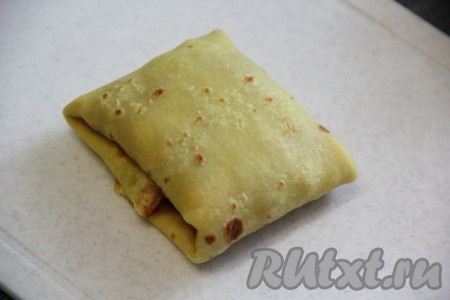 Свернуть блинчик с начинкой в виде конвертика.