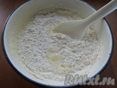 Всыпать разрыхлитель, частями начать добавлять просеянную муку, тщательно перемешивая тесто ложкой.