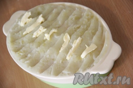 Поверх рыбы выложить слой из картофельного пюре и пару кусочков сливочного масла. Отправить запеканку в разогретую до 200 градусов духовку примерно на 25-30 минут и готовить до золотистого цвета.
