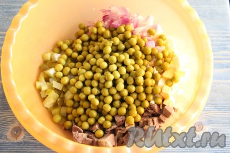 С консервированного горошка слить жидкость и добавить в салат из сердца, лука, огурцов и яиц.
