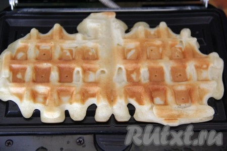 Элетровафельницу хорошо разогреть. У меня поверхность для выпечки тефлоновая и не требует смазки маслом. Если у вас панели вафельницы без тефлонового покрытия, тогда слегка смажьте их растительным маслом. Выложить на каждую часть вафельницы 3 столовых ложки теста (то есть одновременно будут выпекаться 2 вафли). Плотно закрыть створки вафельницы. Выпекать вафли до золотистого цвета. Готовые вафли переложить на решётку, дать остыть.