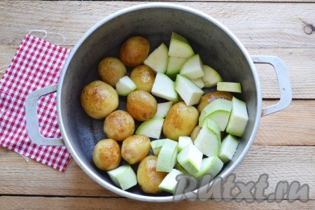 Выкладываем картофель в толстостенную кастрюлю. Кабачок моем (с молодого кабачка шкурку снимать не надо), нарезаем кружочками (тонко нарезать не надо, чтобы в процессе приготовления кабачки не разварились), затем каждый кружок делим на 4 части и выкладываем к картошке.
