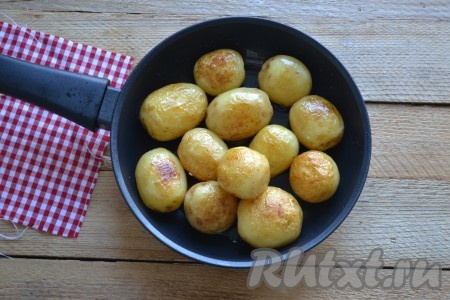 Очищаем картофель от кожуры (лучше брать картошку некрупную, примерно одинакового размера), моем и выкладываем на разогретую сковороду с небольшим количеством масла, обжариваем до золотистой корочки со всех сторон под закрытой крышкой. Периодически необходимо помешивать, делая круговые круги сковородой, не открывая крышку.