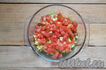 Помидоры нарезаем на мелкие кубики, выкладываем половину помидоров следующим слоем. Далее опять кладём слой кабачков, посыпаем частью натёртого сыра, выкладываем кабачки и оставшиеся помидоры.&nbsp;