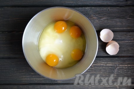 В чашу всыпаем весь взвешенный сахар и вбиваем куриные яйца. 