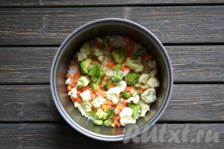 Всыпаем к рису овощи, которые заранее достали из морозилки, аккуратно перемешиваем массу лопаткой, делая движения "вверх-вниз". Вливаем 60 мл воды и включаем функцию мультиварки "Плов" на 15 минут.
