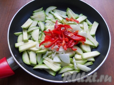 Обжарить слегка брусочки кабачка, иногда помешивая, затем добавить нарезанный кусочками репчатый лук и нарезанный соломкой сладкий перец, влить соевый соус.
