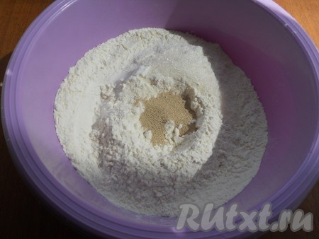Муку просеять, сделать углубление, всыпать соль, сахар и сухие дрожжи.
