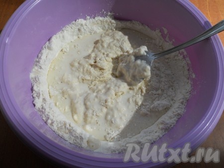 Воду смешать с молоком и, постепенно вливая жидкость в муку вместе с 2 столовыми ложками растительного масла, перемешивать ложкой, замешивая тесто.
