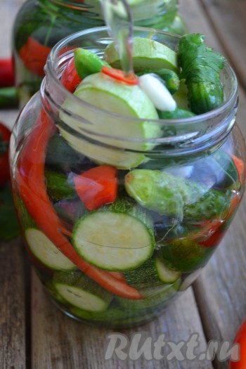 Залить кипятком заполненные банки овощного ассорти, накрыть крышками и оставить на 10 минут.
