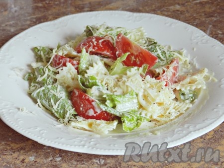 Добавить помидоры, еще раз перемешать. Разложить салат по тарелкам, поперчить молотым черным перцем, если надо - досолить. Посыпать оставшимся тертым сыром и подавать. Вкуснейший салат с макаронами и помидорами готов.
