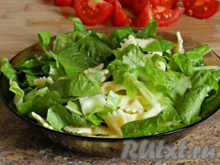 Листья салата порвать руками и смешать с макаронами.