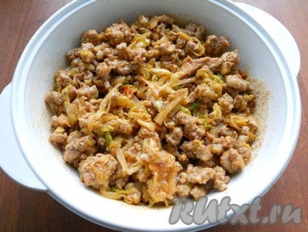 Далее половину теста вылить в форму, выложить начинку из капусты и фарша.