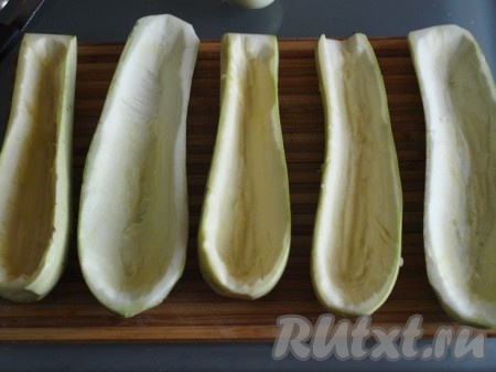 Для этого блюда лучше взять молодые кабачки с мелкими семечками. Кабачки разрезать вдоль на 2 части (с молоденьких кабачков шкурку можно не снимать). При помощи столовой ложки&nbsp; вынуть сердцевину кабачков (мякоть). Отложить мякоть кабачка. Получившиеся лодочки посолить с двух сторон.&nbsp;
