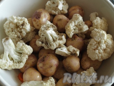 Цветную капусту разобрать на соцветия, добавить к картофелю и моркови, посолить, поперчить, влить растительное масло, посыпать&nbsp;базиликом, майораном, хорошо перемешать. К овощам добавить пару зубчиков чеснока, нарезанных на пластины.
