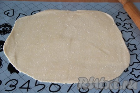 Готовое тесто тонко раскатать на силиконовом коврике или на столе, присыпанном мукой, в прямоугольный пласт.
