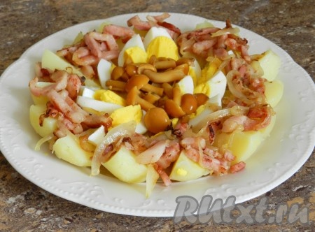 На яйца выложить маринованные грибы.