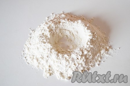 Пока готовится мясной бульон, приготовим домашнюю лапшу: просеянную муку высыпаем горкой на стол. В центре делаем углубление и всыпаем соль.
