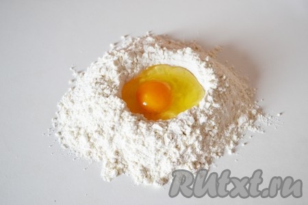 В центр вбиваем яйцо и добавляем 1 столовую ложку холодной воды.
