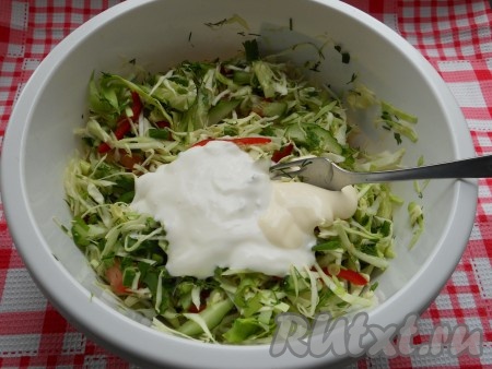 Добавить майонез и сметану в салат из свежей капусты, болгарского перца, помидоров, огурцов, чеснока и зелени.
