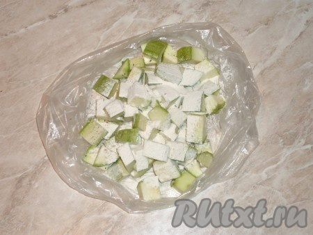 Добавить муку. Пакет закрыть и несколько раз хорошо встряхнуть, чтобы содержимое хорошо перемешалось и все кубики кабачка равномерно покрылись мукой и специями.&nbsp;
