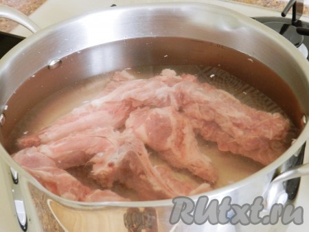 Основа любого борща - вкусный, насыщенный бульон. Свиные ребра залить двумя литрами холодной воды и поставить на огонь. Когда вода закипит, тщательно снять всю пену, уменьшить огонь до минимального и варить в течение 1 часа.
