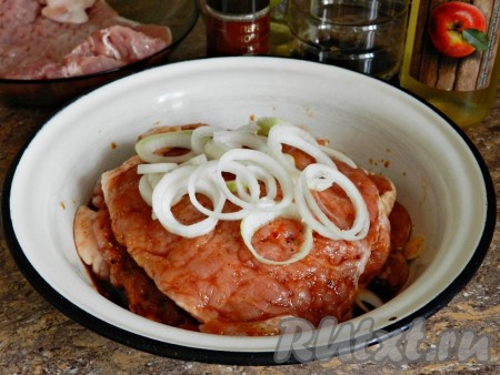 Натереть свинину равномерно со всех сторон маринадом, добавить кольца лука, перемешать и, накрыв пищевой пленкой, оставить мариноваться на 2 часа или более.
