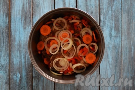 Нарезаем очищенные лук и морковь кольцами. С перца удаляем короб с семенами и нарезаем соломкой. Выкладываем овощи в чашу мультиварки к мясу.
