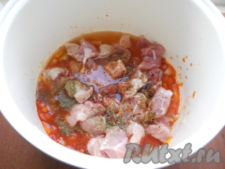 Свинину нарезать небольшими кусочками, выложить в чашу с овощами. Посолить, посыпать специями, добавить паприку и сахар. Влить горячую воду.
