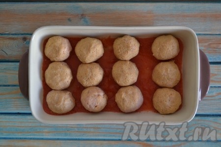 Смачивая руки водой, формируем из приготовленного фарша мясные шарики и выкладываем их в форму для запекания.