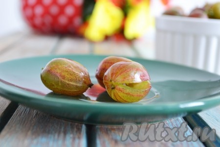 Крыжовник моем под проточной водой. Это удобно делать в сите - вода сливается все чище и чище. Удаляем хвостики и соцветья. Сбоку делаем небольшой надрез острым ножом и удаляем косточки. Это нужно делать тщательно.
