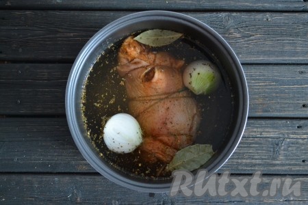 Заливаем рулет из свиной рульки водой так, чтобы она была на 2 см выше уровня мяса.
