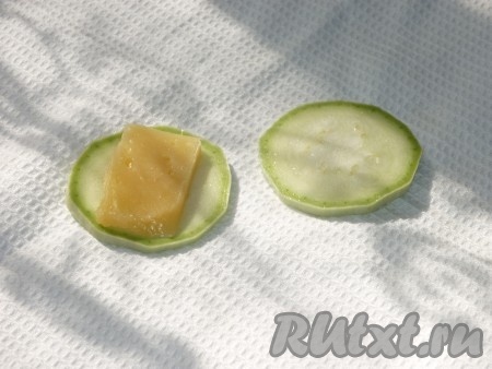 Сыр нарезать тонкими пластинками и положить по одной пластинке между двумя кружочками кабачка. 