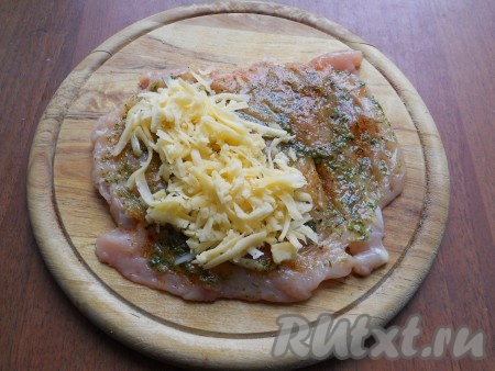 Сыр натереть на крупной терке и выложить его на одну часть куриного филе.