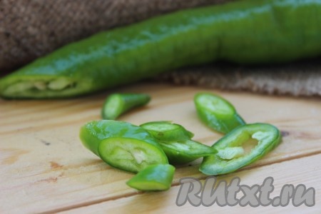 Тонко нарезать половинку стручка жгучего перца, удаляя семена.