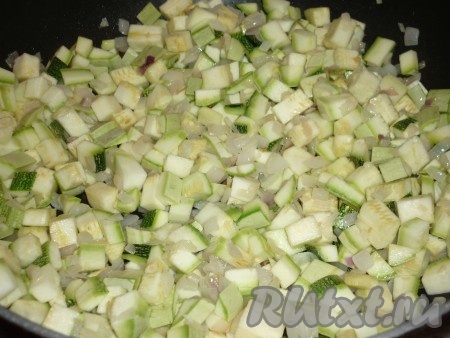 Молодые кабачки среднего размера вымыть под холодной проточной водой. Обрезать хвостики (кожуру можно не очищать с молодых кабачков). Нарезать кабачки небольшими кубиками и добавить к луку и чесноку, готовить 15 минут, помешивая, посолить и поперчить по вкусу. Крышкой сковороду накрывать не надо. По истечении времени кабачки станут достаточно мягкими (обжаривать до золотистой корочки не нужно, кабачки должны стать мягкими).